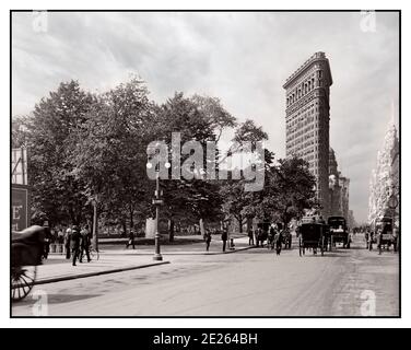 Vintage B&W 1900 Flatiron Building und Madison Square Park New York, mit Pferdekutschen Manhattan USA 1906 das Flatiron Building ist ein dreieckiges, 22-stöckiges, 285 Fuß hohes, mit Stahlrahmen versehene Gebäude mit Grundkennzeichen an der 175 Fifth Avenue im Viertel Flatiron District im Stadtteil Manhattan, New York City. Entworfen von Daniel Burnham und Frederick Dinkelberg, Stockfoto