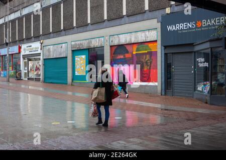 Zwei Frauen gehen entlang einer verregneten High Street, in Southend-on-Sea, Essex, Großbritannien. Southend on Sea ist jetzt ein Tier-4-Gebiet und folgt einer britischen Regierung Stockfoto