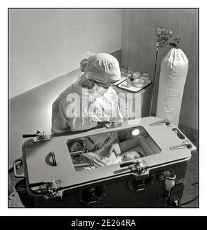 1940er INKUBATOR Krankenhaus vorzeitige Baby-Einheit November 1942. New York. Pflege von früh geborenen Babys komplizierte Verfahren, die von einer studentischen Krankenschwester gelernt werden müssen. Fütterung, Baden etc. Werden im Inkubator durchgeführt, in dem Temperatur, Feuchtigkeit und Sauerstoff mit Sauerstoffversorgung im Hintergrund sorgfältig geregelt werden müssen.“ Eine neonatale Intensivstation, auch als Intensivstation bekannt, ist eine Intensivstation, die sich auf die Betreuung von kranken oder frühgeborenen Neugeborenen spezialisiert hat. Stockfoto