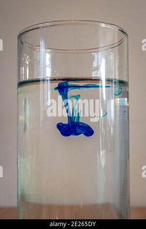 Fluiddynamik-Experiment, wo ein Tropfen blauer Farbstoff ist In Wasser geben Stockfoto