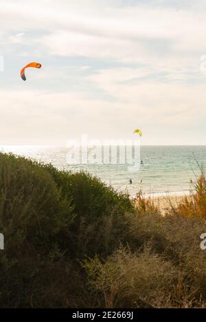 Viele Kitesurfer mit ihren Drachenschirmen in der Luft Am Strand von Tarifa Stockfoto