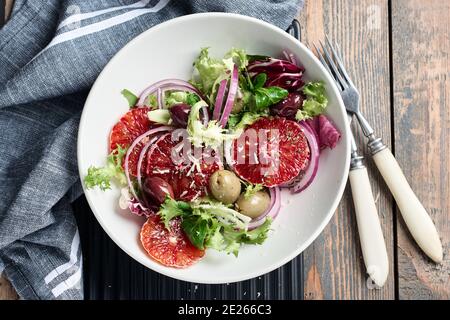 Sizilianischer Orangensalat. Salat mit Blutorange, roten Zwiebeln und Oliven, Draufsicht. Stockfoto