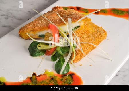 Mozzarella in Carrozza, italienisches gegrilltes Käse-Sandwich. In Scheiben geschnittenes gebratenes Brot mit geschmolzenem Mozzarella auf einem Teller mit Salatblättern Stockfoto