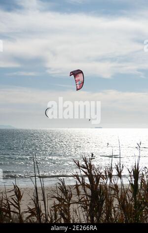 Viele Kitesurfer mit ihren Drachenschirmen in der Luft Am Strand von Tarifa Stockfoto