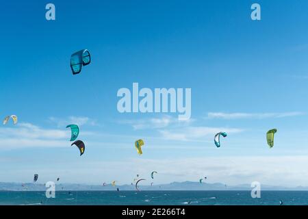 Viele Kitesurfer mit ihren Drachenschirmen in der Luft Am Strand von Tarifa Stockfoto