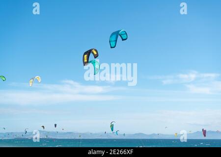 Viele Kitesurfer mit ihren Drachenschirmen in der Luft Am Strand von Tarifa Stockfoto