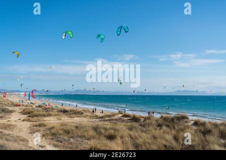 Viele Kitesurfer mit ihren Drachenschirmen in der Luft Am Strand von Tarifa Stockfoto