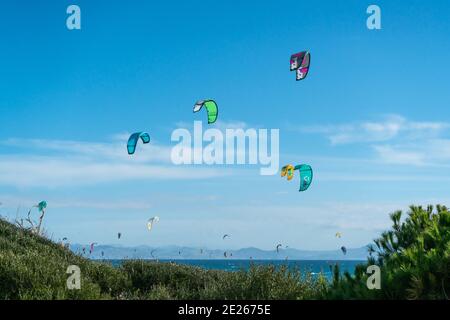 Viele Kitesurfer mit ihren Drachenschirmen in der Luft Am Strand von Tarifa Stockfoto