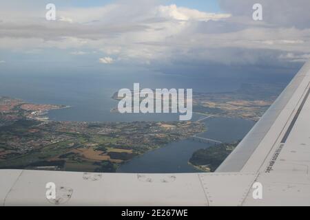 Blick über Land und Wasser aus einem Flugzeugfenster Stockfoto