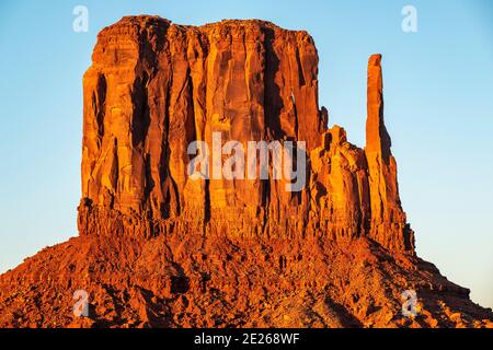 Sonnenuntergang auf der West Mitten Felsformation im Monument Valley Navajo Tribal Park, der die Arizona und Utah State Line, USA, überspannt Stockfoto