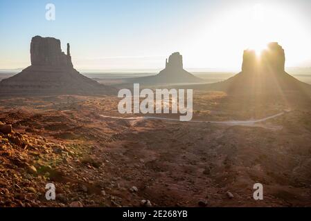 Ikonische Ansicht des Sonnenaufgangs auf den Felsformationen West Mitten, Ost Mitten und Merrick Butte im Monument Valley Navajo Tribal Park, Arizona und Utah, USA Stockfoto