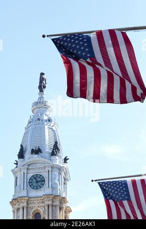 Amerikanische Flaggen fliegen von Flagstaffs in der Nähe des Turms der Philadelphia City Hall in Philadelphia, USA. Stockfoto