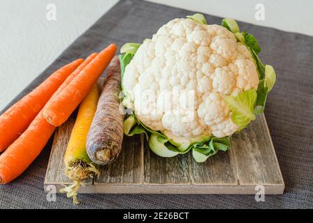 Frischer roher Bio-Blumenkohl und Karotten aus nächster Nähe in der Küche Tabelle Stockfoto