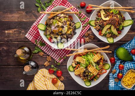 3 Sorten Salat mit Quinoa, Halloumi und Steak auf Holztisch Stockfoto