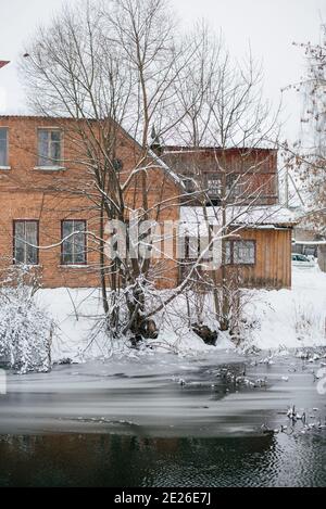 Ein rotes Ziegelgebäude steht auf der anderen Seite von Ein Winterreservoir Stockfoto