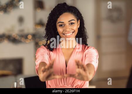 afroamerikanische Frau im Kleid, die Hände zur Kamera reicht Stockfoto