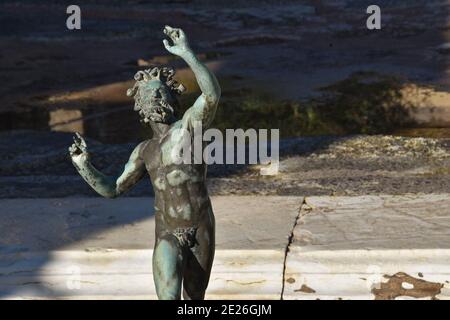 Pompeji, Italien. Tanzende Faun-Statue im Haus des Faun. Italien Tourismus, Kultur, Erbe Hintergrund. Glückliches Leben, freies Lifestyle-Konzept. Stockfoto