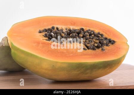 Nahaufnahme der geschnittenen Papaya auf dem hölzernen Brett gegen a Weißer Hintergrund Stockfoto
