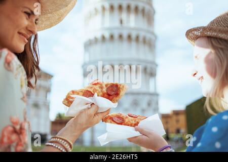 Nahaufnahme einer trendigen Familie mit Pizza in der Nähe des Schiefen Turms in Pisa, Italien. Stockfoto