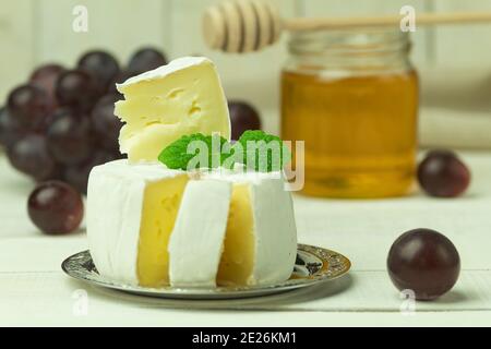 Camembert Käse und Trauben Nahaufnahme mit Platz für Text. Camembert in Schichten geschnitten und Trauben Beeren für Foto-Menü, Catering, Banner, Rezept, Plac Stockfoto