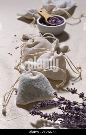 Handgemachte Lavendel-Beutel in Stofftaschen und weiche Baumwollherzen auf weißer Baumwoll-Tischdecke. Lavendelblüten in Pauspapier trocknen. Natürlich hausgemacht Stockfoto