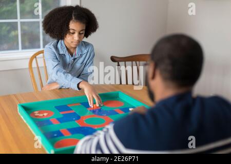 African America zehn Jahre altes Mädchen spielen Brettspiel mit Vater Stockfoto