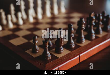 Nahaufnahme von hölzernen Schachfiguren auf einem Schachspielbrett. Stockfoto