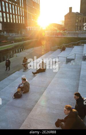 Soziale Distanzierung bei der Pandemie Covid-19 in der Wintersonne auf dem Granary Square bei Kings Cross, Nord-London, Großbritannien Stockfoto