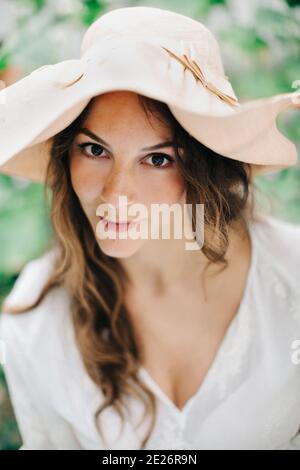Langhaarige Frau trägt Sommerhut Stockfoto