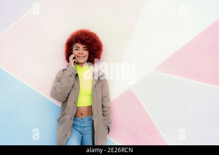 Frau mit afro Haar im Gespräch auf ihrem Smartphone Stockfoto