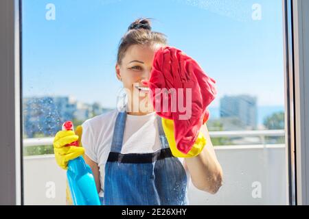 Hausreinigung, reife Frau in Gummihandschuhen trägt eine Schürze Waschfenster Stockfoto