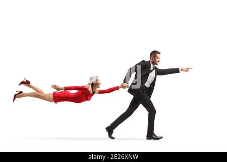Mann im Anzug, der läuft und eine Frau hereinzieht Ein rotes Kleid isoliert auf weißem Hintergrund Stockfoto