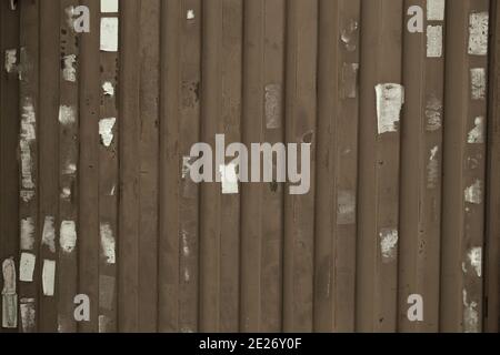 Holzwand oder Zaun mit Plakatresten Stockfoto