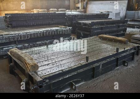 Herstellung von Betonplatten. Stahlbeton Produktion. Arbeiter arbeiten mit Metall, Schweißen Verstärkung für Betonbewehrung. Haus-Gebäude Stockfoto