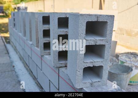 Ein Arbeiter baut eine Blockwand für einen neuen Zu Hause Stockfoto