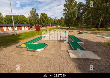 Schöne Landschaft Blick auf Sommer Land Landschaft. Minigolfplatz und rote Häuser auf grünen Bäumen und blauen Himmel mit weißen Wolken Hintergrund. Stockfoto