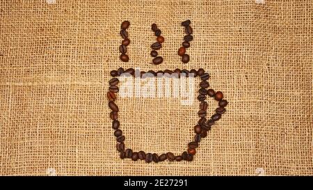 Geröstete Kaffeebohnen in Form von Kaffeetasse Logo angeordnet. Stockfoto