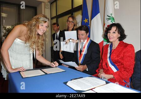Denise Fabre, icone de la television Francaise et actuellement Maire-adjointe de la ville de Nice, a marie civilement sa fille Olivia (en Blanc) avec Charles de Navacelle de Coubertin à la Mairie de Nice, France le 8 Juillet 2011. A ses cotes lors de la ceremonie, le Maire de Nice, Herr Christian Estrosi secondait efficacement la Maire-adjointe, tres emue. Le temoin de la mariee etait Elodie (en vert à la Mairie et en Robe courte beige ensuite) qui n'est autre que la soeur jumelle d'Olivia. Michel Drucker, parrain des 2 filles de Denise Fabre a assiste au mariage. Le mariage religieux ein eu-Lieu Stockfoto