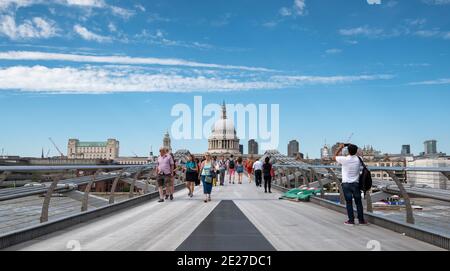 Menschen, die auf der Jahrtausendbrücke und der St. Paul Kathedrale spazieren In London, Großbritannien Stockfoto