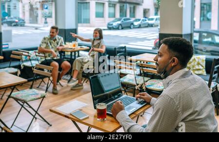 Mann Telearbeit mit Laptop im Café Stockfoto