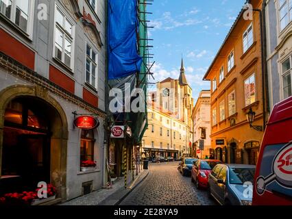 Eine schmale gepflasterte Straße mit Restaurant und Bauzone in der Kleinseite der Mala Strana in Prag, Tschechien. Stockfoto