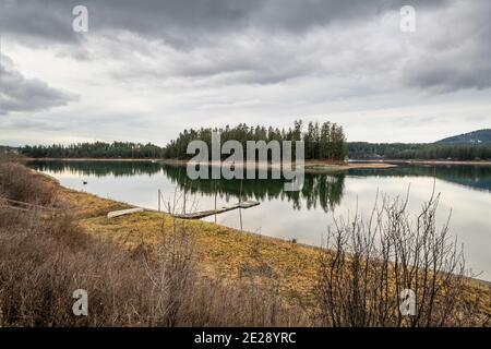 Eine kleine Bootsanlegestelle in der Nähe von Kelly Island, einer kleinen Insel im Priest River in der Nähe der Stadt Newport, Washington, USA, bei bewölktem Himmel. Stockfoto