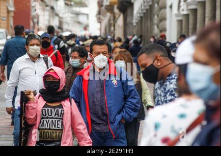 Quito, Ecuador. Januar 2021. Menschen mit Masken gehen während der Corona-Pandemie durch die Stadt. Die Regierung Ecuadors bestätigte am 11. Januar den ersten Fall der Mutation B.1.1.7 im südamerikanischen Land. Die Mutation wurde bei einem 50-jährigen Mann nachgewiesen, der von London über Madrid nach Ecuador kam. Quelle: Juan Diego Montegro/dpa/Alamy Live News Stockfoto