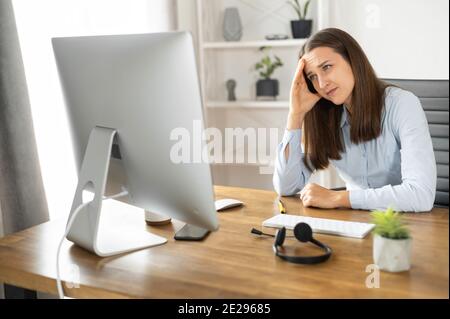Eine junge Frau benutzt im Büro einen PC Stockfoto