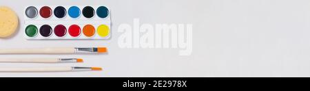 Banner mit künstlerischem Set zum Malen mit neuen Aquarellfarben, Werkzeugen und Pinsel auf weißem Hintergrund. Arbeitsbereich Interpret. Flach liegend, Draufsicht Stockfoto