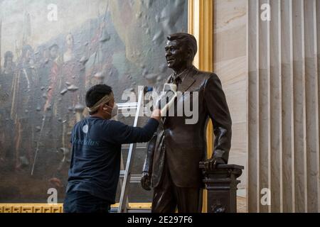 Washington, Vereinigte Staaten Von Amerika. Januar 2021. Ein Mann arbeitet am Aufräumen einer Statue des ehemaligen Präsidenten Ronald Reagan in der Rotunde im US-Kapitol in Washington, DC, Dienstag, 12. Januar 2021. Quelle: Rod Lampey/CNP Credit: dpa/Alamy Live News Stockfoto