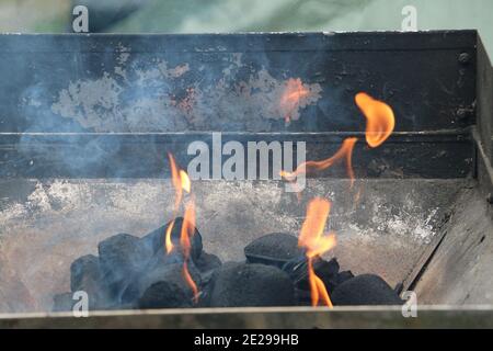 Nahaufnahme der Flammen zwischen den Kohlen im Grill Grill Stockfoto