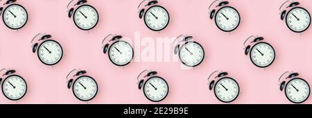 Muster mit schwarzem Wecker auf rosa Hintergrund. Minimaler Stil Draufsicht Banner-Vorlage für Ihren Text, Design. Stockfoto