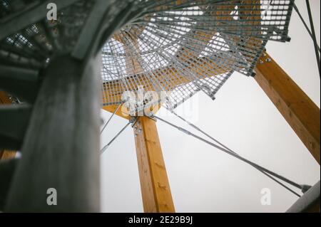 Low-Angle-Aufnahme einer kreisförmigen Stahltreppe mit Netz Eine Holzbaustelle Stockfoto