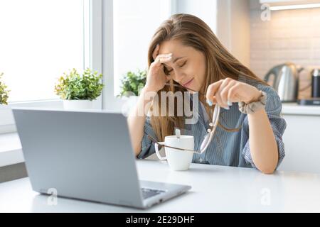 Verärgerte Frau vor dem Laptop-Monitor im Inneren des Hauses. Stockfoto